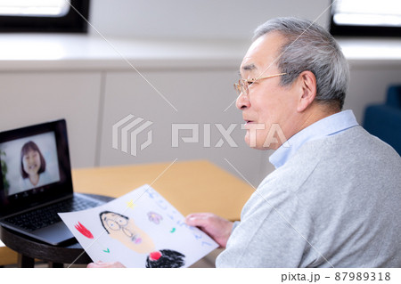 ビデオ通話 オンラインで繋がった孫と話をするシニア男性 ビデオ通話 オンラインで繋がった孫と話をするシニア男性 87989318