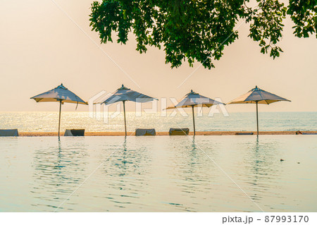 Umbrella and chair around swimming pool with sea ocean view Umbrella and chair around swimming pool with sea ocean view 87993170