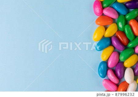 Overhead view of sweet multi colored candies on blue background with copy space Overhead view of sweet multi colored candies on blue background with copy space 87996232