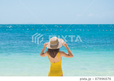 Woman tourist in yellow swimsuit and hat, happy traveler sunbathing at Paradise beach on Islands. destination, wanderlust, Asia Travel, tropical summer, vacation and holiday concept Woman tourist in yellow swimsuit and hat, happy traveler sunbathing at Paradise beach on Islands. destination, wanderlust, Asia Travel, tropical summer, vacation and holiday concept 87996876