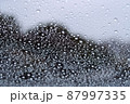 雨滴の付いたガラス越しに見た外景で雨の日の素材 87997335