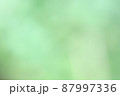 濃淡のあるうすい緑色のぼけた背景素材 87997336