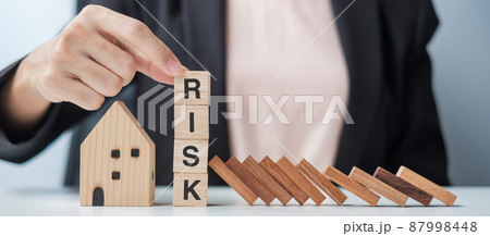Businessman stop falling wooden blocks and protect house model. Crisis, fall Business, Risk, Economic recession, Developer, Real Estate and Property concept Businessman stop falling wooden blocks and protect house model. Crisis, fall Business, Risk, Economic recession, Developer, Real Estate and Property concept 87998448