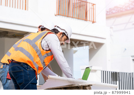 Architect concept,Architects and businessman working with blueprints at construction site. Architect concept,Architects and businessman working with blueprints at construction site. 87999941