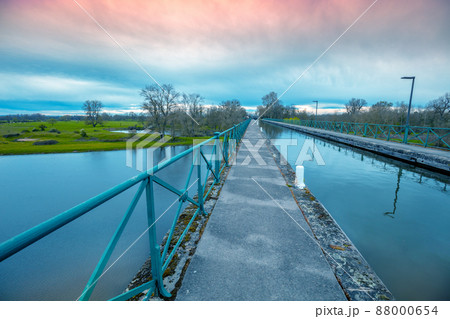 Boat canal bridge over Laura river in early spring at sunset. Digoin, France. 88000654