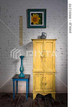 Vintage yellow cupboard, framed painting, blue candlestick and small table 88001240