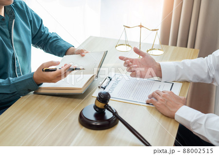 Law consultancy concept A white-shirt lawyer discussing about the contract with his dealer and writing it down on his notebook. 88002515
