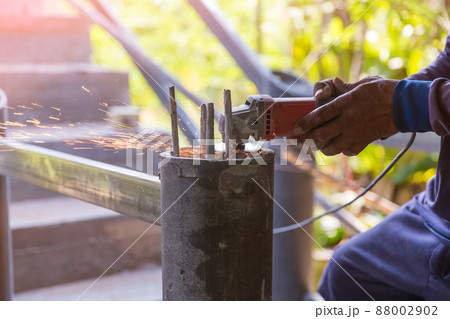Worker cutting metal with grinder. Sparks while grinding iron. 88002902