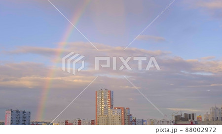 Multicolored rainbow and clouds in the sky after the rain and multi storey buildings in the city 88002972