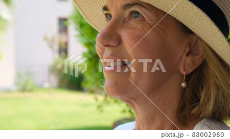 portrait of a mature woman 55-60 years old with a toothy smile in a sun-protective straw hat 88002980