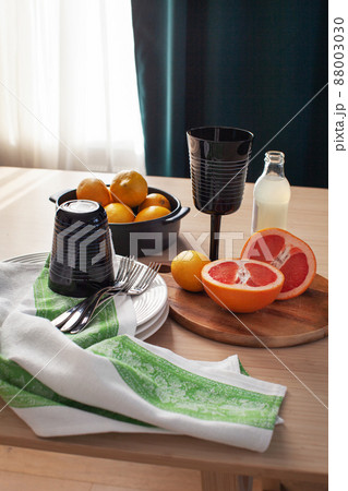 Fresh citrus fruits, black glass and bottle of lemonade on wooden table. Healthy cold drink, lemon and grapefruit on dark background 88003030