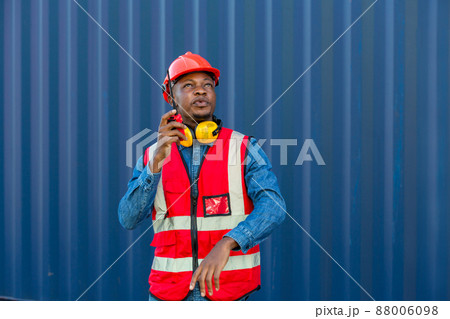 Foreman holding walkie- talkie for control working at Container cargo site. Foreman holding walkie- talkie for control working at Container cargo site. 88006098