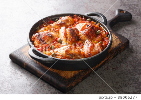 Spanish food chicken baked with tomato, pepper, onion and garlic sauce close-up on a cutting board. horizontal 88006277