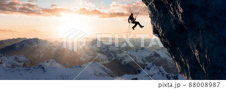 Adult adventurous man rappelling down a rocky cliff. Extreme adventure composite. Adult adventurous man rappelling down a rocky cliff. Extreme adventure composite. 88008987