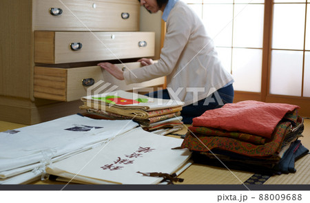 着物ダンスを整理する中年女性 88009688