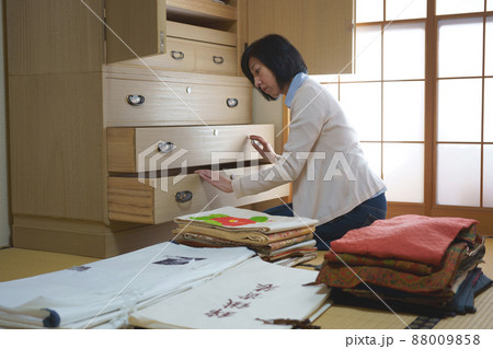 着物ダンスを整理する中年女性 88009858