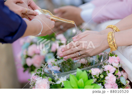 Hands pouring blessing water into bride's bands 88010520