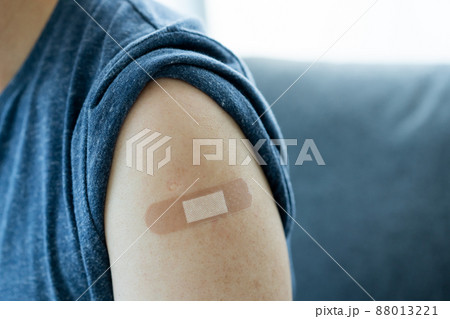Happy Asian young woman showing an OKAY sign beside her arm after she took a vaccine shoot. Woman having a COVID-19 cure vaccine at medical center. Happy Asian young woman showing an OKAY sign beside her arm after she took a vaccine shoot. Woman having a COVID-19 cure vaccine at medical center. 88013221