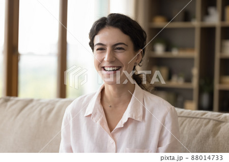 Happy attractive young Hispanic woman sitting on couch. Happy attractive young Hispanic woman sitting on couch. 88014733
