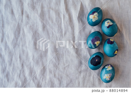 Pressed flower Easter eggs on beige tablecloth. 88014894