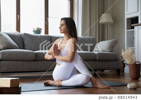 Young sporty woman perform Ardha Matsyendrasana practicing yoga at home 88014943