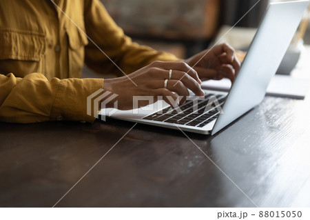 African female employee working at laptop, typing on keyboard 88015050