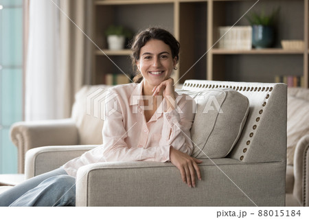 Portrait of smiling young Hispanic woman resting on couch. Portrait of smiling young Hispanic woman resting on couch. 88015184