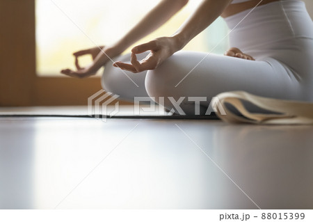 Cropped image woman do meditation practice sit cross-legged on mat 88015399