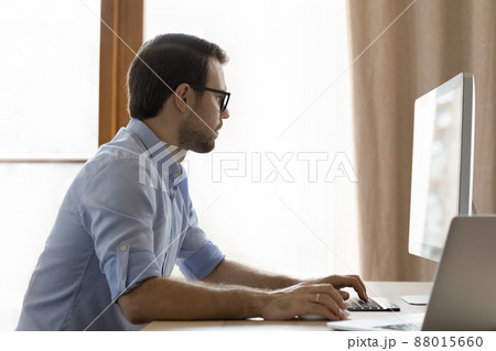 Serious businessman in glasses using pc work on project online Serious businessman in glasses using pc work on project online 88015660