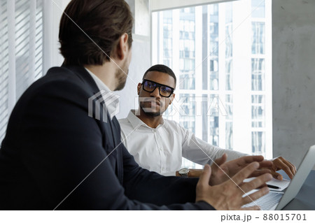 Young two diverse business partners discussing online project. Young two diverse business partners discussing online project. 88015701