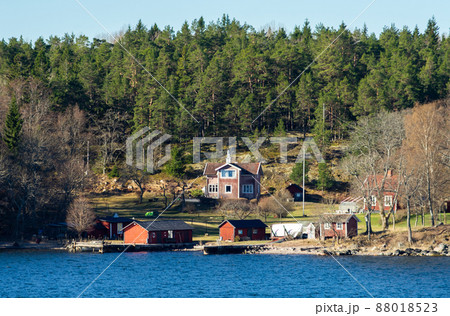 Picturesque summer houses painted in traditional falun red on dwellings island of the Stockholm archipelago in the Baltic Sea in the early morning. 88018523