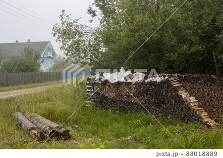 A stack of firewood and logs on the side of the road in the village 88018889
