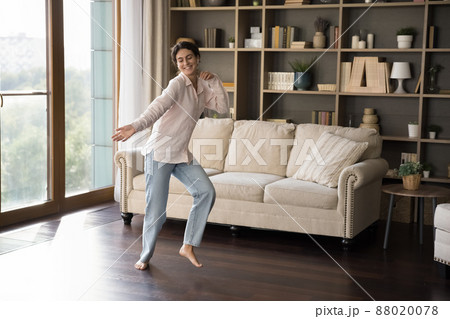 Happy carefree Hispanic woman dancing at home. 88020078