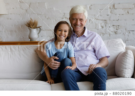 Portrait of friendly loving grandson and granddad sit on sofa 88020190