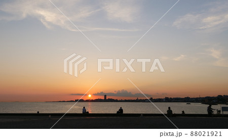 海辺から見た夕景。夕日を眺める人々。(シルエット) 88021921