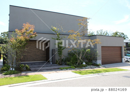 青空に映える箱型の道路面に窓がないアースカラーのスタイリッシュで高級感のあるおしゃれな美しい邸宅 88024169