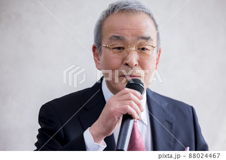 ビジネス　マイクを持ってスピーチをするシニア男性 88024467