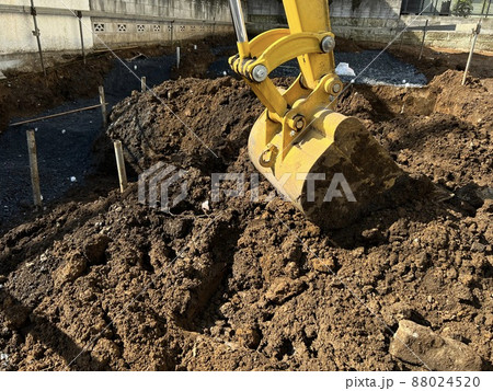 市街地の建築現場で作業する建設機械（油圧ショベル） 88024520