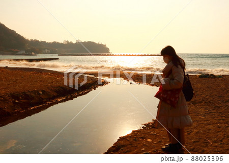 駿河湾の海の夕陽と一人旅女性のシルエット 88025396