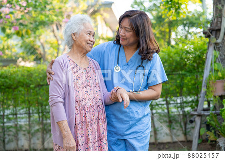 Doctor help and care Asian senior or elderly old lady woman use walker with strong health while walking at park in happy fresh holiday. 88025457