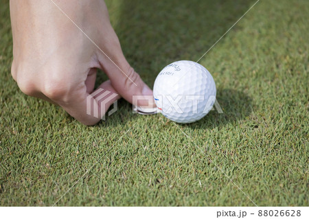 ゴルフイメージ　グリーンでボールのマーキングをする女性手元 88026628