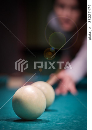 Blurry silhouette of a girl playing billiards in the club 88027476