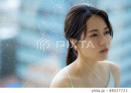 窓辺の女性　頭痛　悩み 88027721