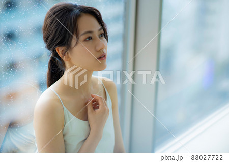 窓辺の女性　頭痛　悩み 88027722