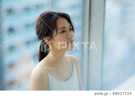 窓辺の女性　頭痛　悩み 88027724
