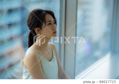 窓辺の女性　頭痛　悩み 88027725