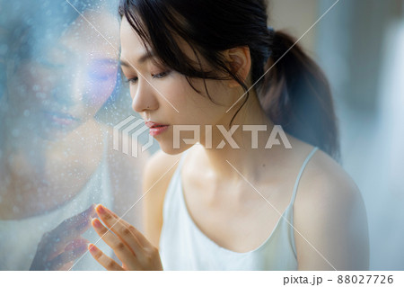 窓辺の女性　頭痛　悩み 88027726