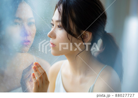 窓辺の女性　頭痛　悩み 88027727