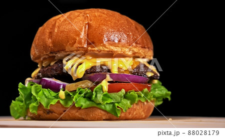 Craft burger is cooking on black background. Consist: sauce, lettuce, tomato, red onion, pickle, cheese, bacon, air bun and marbled meat beef. Craft burger is cooking on black background. Consist: sauce, lettuce, tomato, red onion, pickle, cheese, bacon, air bun and marbled meat beef. 88028179