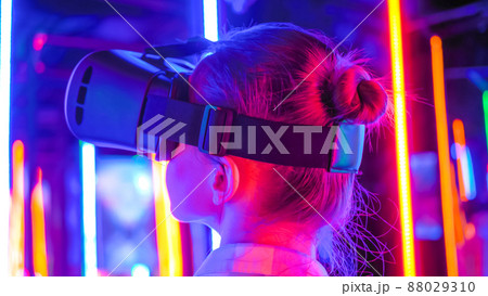 Back view: woman using virtual reality headset at interactive VR exhibition 88029310